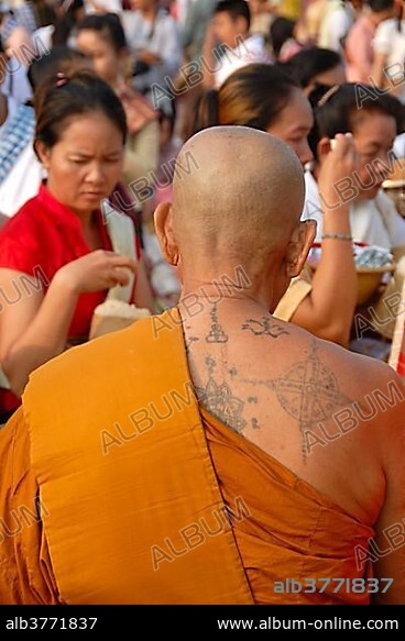 Theravada Buddhism, That Luang Festival, Tak Bat, tattoos, monk with spiritual tattoos on his back and bald head, believers, pilgrims giving alms, orange robes, Vientiane, Laos, Southeast Asia, Asia.