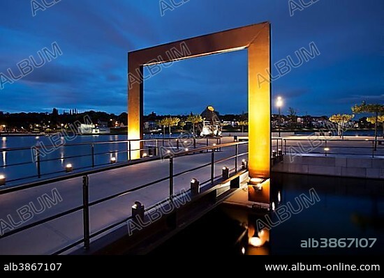 Illuminated promenade with the Thomas Smelting Furnace on Kulturinsel, the cultural island in Phoenix-See lake at dusk, Dortmund, Ruhr district, North Rhine-Westphalia, Germany, Europe.
