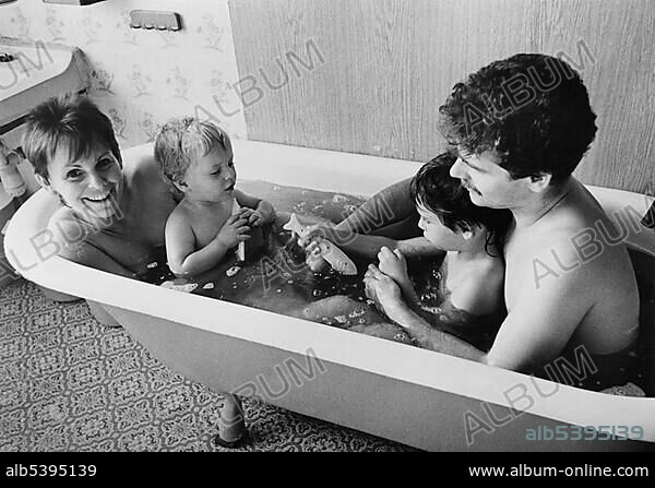 Young family in a bath tub, East Germany, Europe, circa 1986.