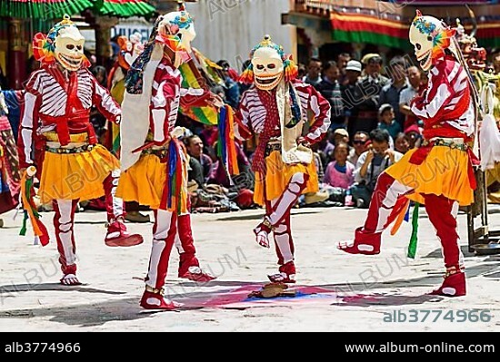 Monks with big wooden masks and colorful costumes are performing ritual dances at Hemis Festival in the courtyard of the monastery, Hemis, Jammu and Kashmir, India, Asia.