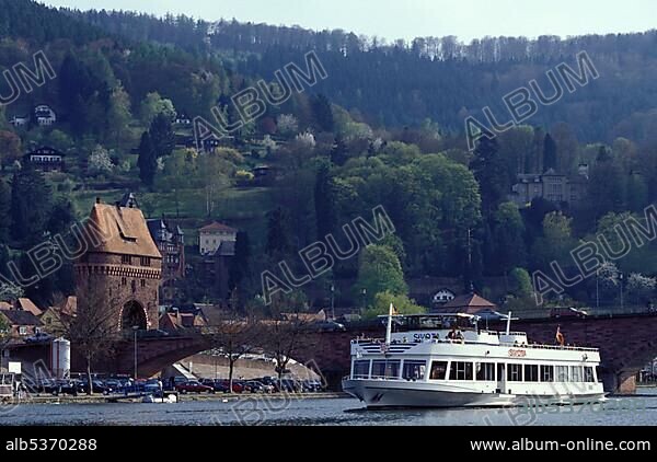 Germany: Miltenberg on the Main river, Bavaria, capital city of the same named county, left: tower of the bridge across the river named "Main", front: tourist boat in spring time.