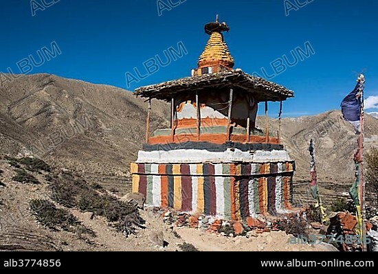 Colourfully painted Buddhist stupa in front of mountain landscape, Samar, Mustang, Nepal, Asia.