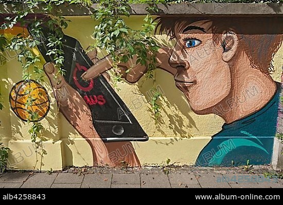 Graffiti on wall, man turns off smartphone, Munich, Upper Bavaria, Bavaria, Germany, Europe.