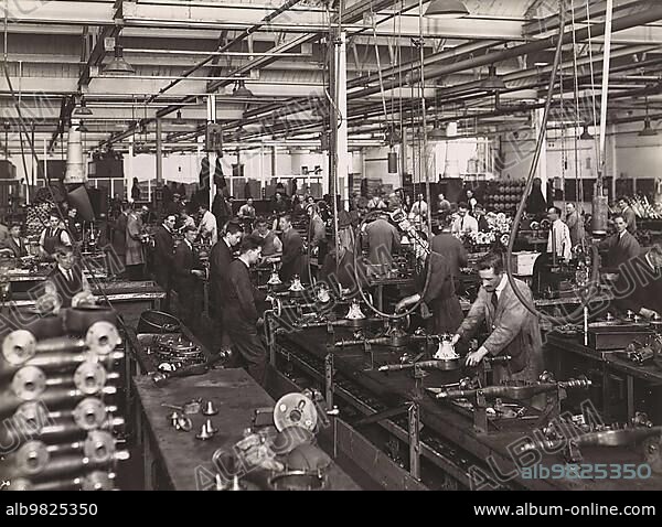 Wolseley factory interior with workers at machinery; Wolseley Motor Company was a British car manufacturer; Birmingham; 1932; England; Historic; digitally restored reproduction from a 19th century original.