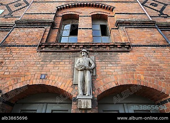 Statue of a tobacco worker, circa 1883, above the entrance of the Speicherstadt warehouse district, Hamburg, Germany, Europe.
