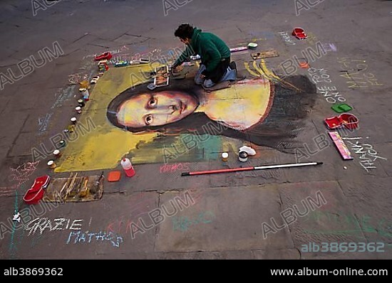 Street artist paints the Mona Lisa by Leonardo da Vinci with chalk on the asphalt, Siena, Italy, Europe.