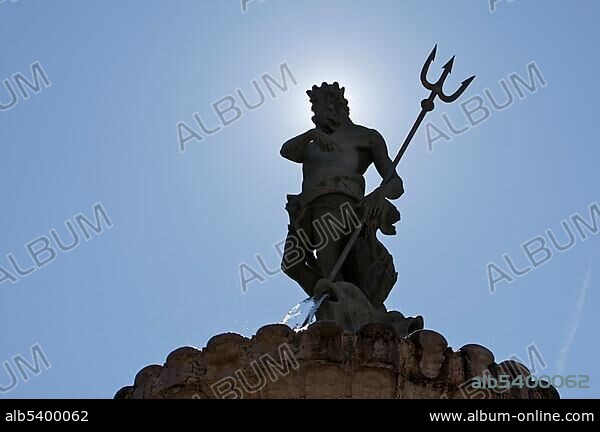 Statue of Neptune, Neptune Fountain backlit on the cathedral square in Trento, Northern Italy, Europe.