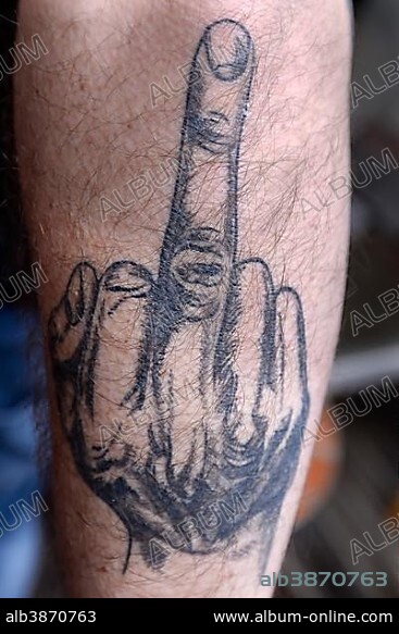 Tattoo with middle finger on arm, Germany, Europe.