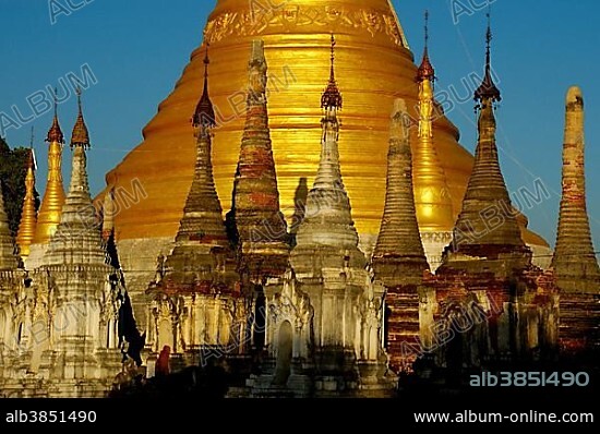 Bas of a big golden stupa with many small stupas in front Pindaya Shan State Burma.