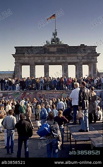 Fall of the Berlin Wall, people from East and West Berlin climbing on the Wall at the Brandenburg Gate, Berlin, Germany, Europe.