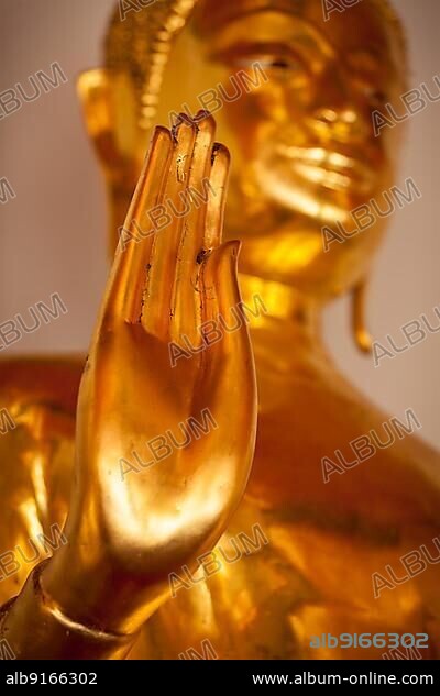 Buddha golden statue blessing hand, Wat Pho, Bangkok, Thailand. Low point of view.