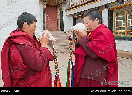 Buddhist nuns in the Terdom monastery call with the conch horn, nunnery Tidro Gompa, terdrom, Tirdrom, Tibet, China, Asia.