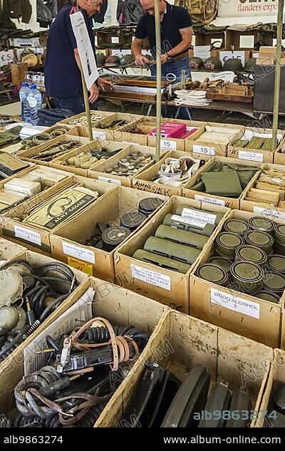 Vendor in WWII stand selling military memorabilia to World War Two collector at WW2 militaria fair.