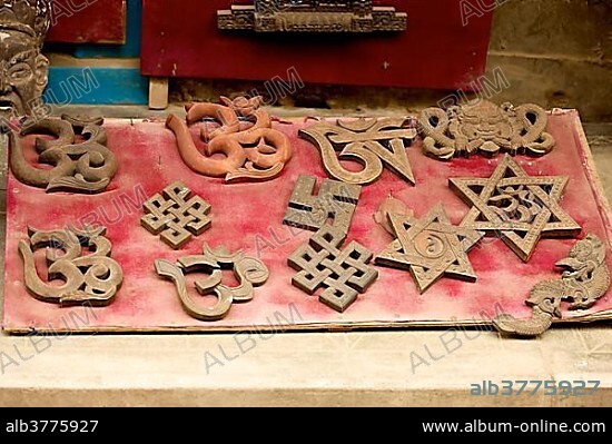 Hindu and Buddhist symbols, including the swastika, the Star of David and the Aum symbol, Om symbol, in a shop window, Patan, Nepal, Asia.