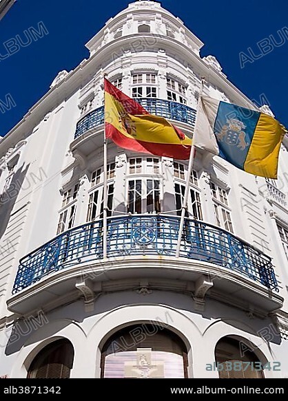Spanish flag, left, and a flag of the Canary Islands, right, blowing on an Art Nouveau building, Santa Cruz, La Palma, Canary Islands, Spain, Europe.