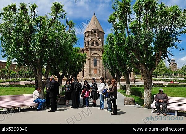 Armenian orthodox priest, monk discussing with people, with main cathedral at Echmiadzin, Unesco World Heritage Site, Armenia, Asia.