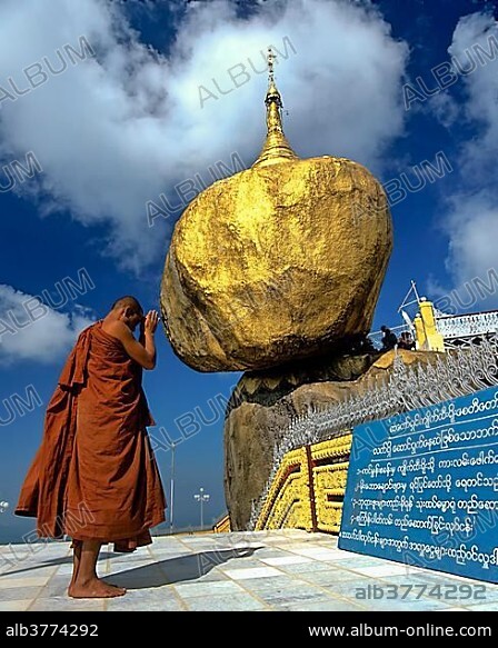 Buddhist Monk praying in front of the Golden Rock or Kyaiktiyo Pagoda, Kyaikto, Mon-Staat, Myanmar, Burma, Asia.