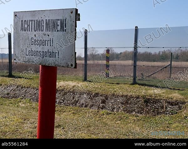Ein Schild warnt vor Minen an der Gedenkstätte Stresow, Sachsen-Anhalt. Nach der Teilung Deutschlands lag das Dorf Stresow im Schutzstreifen des Grenzgebiets der ehemaligen DDR. Die Bewohner wurden zwangsausgesiedelt und das Dorf abgerissen. Nach der Wiedervereinigung Deutschlands wurde 1997 zur Erinnerung eine Gedenkstätte errichtet und ein Gedenkstein enthüllt. Seehausen (Altmark), Sachsen-Anhalt, Deutschland.