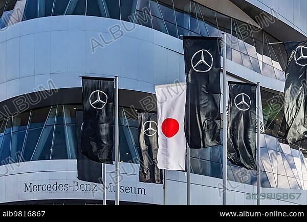 Mercedes-Benz Museum; Stuttgart; architecture Ben van Berkel; UNStudio. In front of it flags of Mercedes and the flag of Japan; automotive industry; Stuttgart; Baden-Württemberg; Germany; Europe.