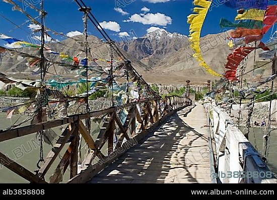 Swing bridge with prayer flags over the Indus river, Ladakh, Jammu and Kashmir, India, Asia.