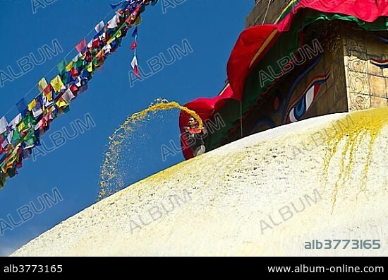 Worker renewing the yellow paint of Boudnath Stupa, Kathmandu Valley, Kathmandu, Kathmandu District, Bagmati Zone, Nepal, Asia.