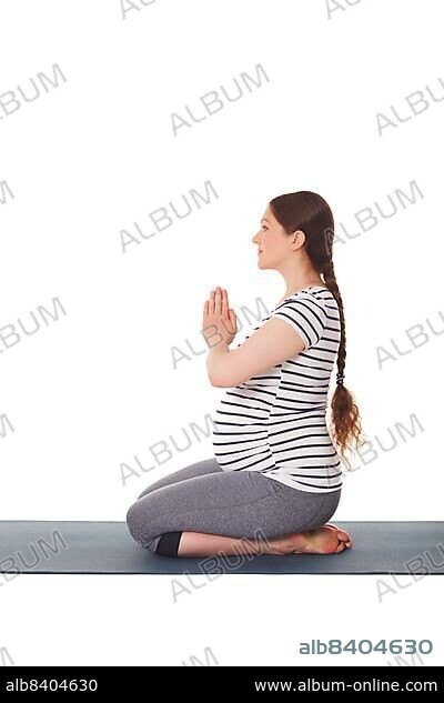 Young pregnant woman in sportswear meditating in lotus pose at home Stock  Photo by Prostock-studio