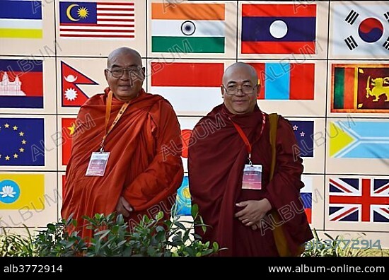 Two monks with red and orange robes, participants of the Global Buddhist Congregation 2011, Buddhist dignitaries from various Buddhist traditions and schools are photographed in front of national flags in Nehru Park, Gandhi Smitri, New Delhi, India, Asia.