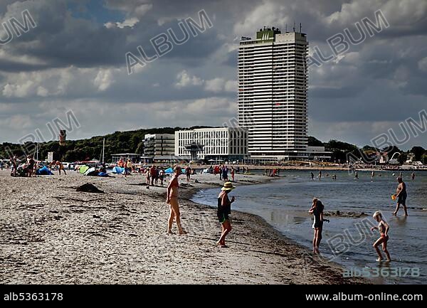 Baltic Sea beach of the peninsula Priwall at the mouth of the river Trave, sandy beach, vacationers, bathers, high-rise building in Travemünde, sea, Kolonnenweg, Lochplattenweg, inner-German border fortification, Grünes Band, border path, Travemünde, Lübeck, Schleswig-Holstein, German.