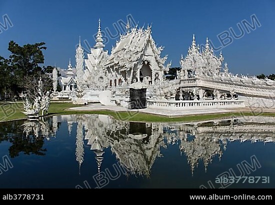 Wat Rong Khun, White Temple, by architect Chalermchai Kositpipat, ubosot reflected in the water, Chiang Rai, Chiang Rai Province, Northern Thailand, Thailand, Asia.