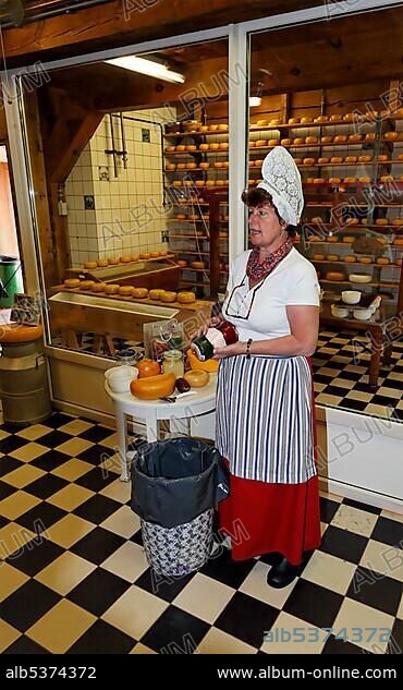 Woman in traditional Dutch costume explaining cheesemaking, cheese dairy Katharina Hoeve, open-air museum Zaanse Schans, Zaandam, North Holland, Netherlands, Europe.
