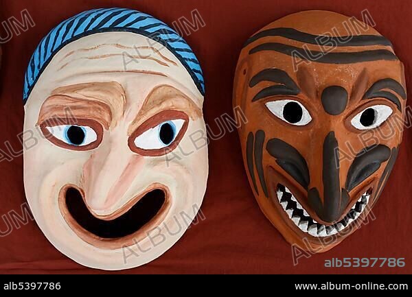 Two grotesque faces, Roman theatre masks made of clay, painted, replicas.