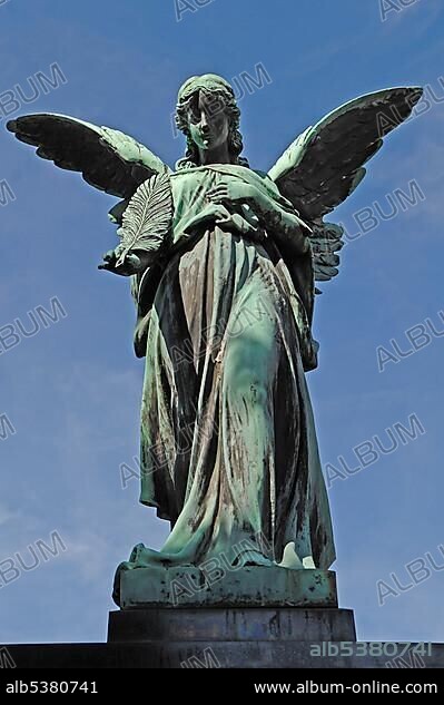 Big statue of an angel on a 19th century family grave against a blue sky, Johannisfriedhof cemetery, founded in the 13th century, Brueckenstrasse street 9, Nuremberg, Middle Franconia, Bavaria, Germany, Europe.