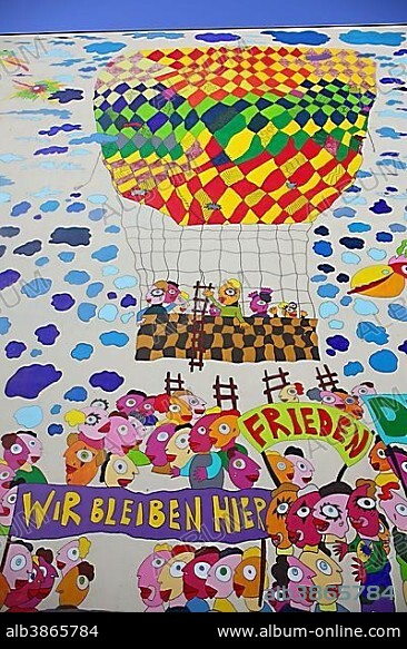 Colourful mural with the words "Frieden" and "Wir bleiben hier", German for "peace" and "We shall remain here," on a wall of the Marriott Hotel Leipzig, Leipzig, Saxony, Germany, Europe.