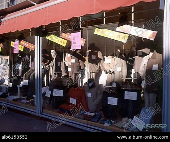 ESCAPARATE DE UNA TIENDA DE ROPA EN REBAJAS CON LOS PRECIOS EN EUROS Y EN PESETAS.