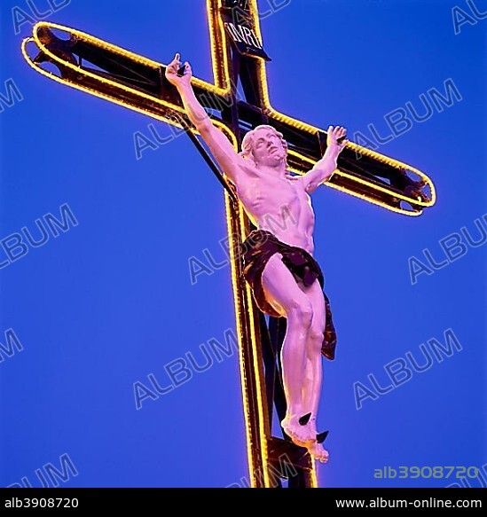 Jesus Christ on Crucifix with neon lights and blue sky.