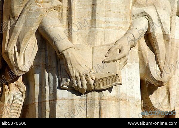 Calvin Statue, close-up of his hands holding the bible, engraved in stone, reformation wall, International reformation memorial in Geneva, Calvin Year 2009, Switzerland, Europe.