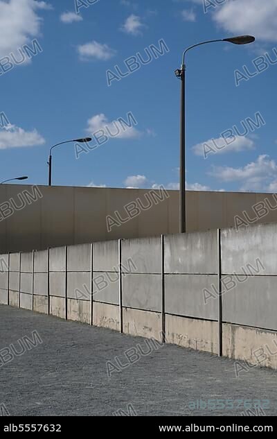 Betonelemente, eine Stahlwand und hohe Lampen als Teil der Gedenkstätte Berliner Mauer, Bernauer Straße, Bezirk Mitte, Berlin, Deutschland.