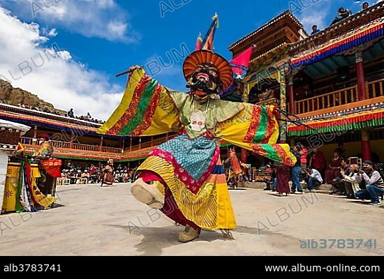 Monks with big wooden masks and colorful costumes are performing ritual dances at Hemis Festival in the courtyard of the monastery, Hemis, Jammu and Kashmir, India, Asia.