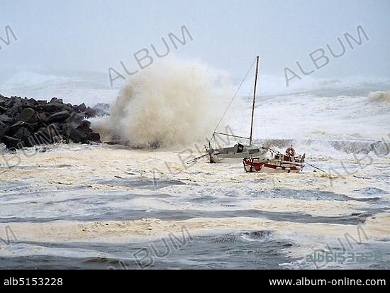 High waves crashing over rocks, rocking small boats, stormy seas on the Brittany coast, hurricane, Finistere, Brittany, France, Europe.
