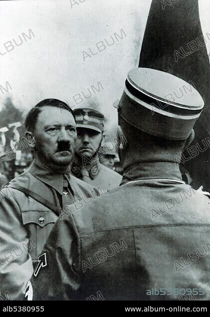 Adolf Hitler "consecrating" new flags with the Blutfahne blood flag, behind him chief of staff Viktor Lutze, historical photo between 1933-1943.