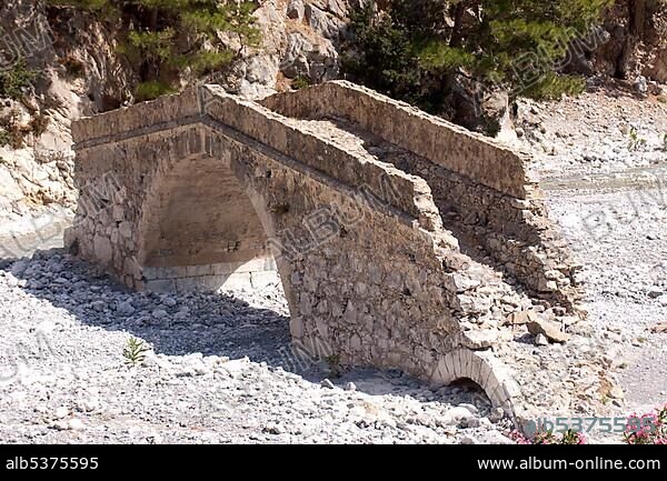An old bridge from the Roman period spans the dry river bed in the Samaria Gorge in Agia Roumeli, Crete, Greece, Europe spanned, Europe.