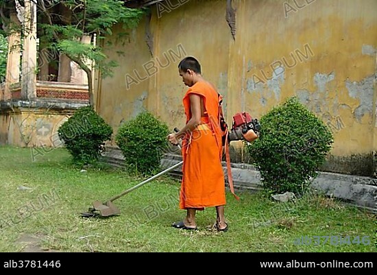 Theravada Buddhism, monk cutting grass with brush cutters, orange robes, Wat Si Saket, Vientiane, Laos, Southeast Asia, Asia.