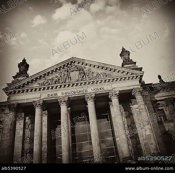 Black and white image, sepia-toned, Reichstag Building, German Parliament, with the inscription, Dem Deutschen Volke, German for To the German People, and a relief in the tympanum over the main portal, Government District, district of Tiergarten, Berlin, Germany, Europe, PublicGround, Europe.