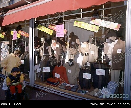 ESCAPARATE DE UNA TIENDA DE ROPA EN REBAJAS CON LOS PRECIOS EN EUROS Y EN PESETAS.