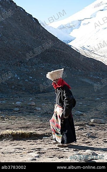 Tibetan Buddhist pilgrim woman in traditional dress with large white head covering, near Dolma La Pass, pilgrimage road to the holy Mount Kailash, Gang Rinpoche, Kora, Ngari, Gang-Tise Mountains, Trans-Himalaya, Himalayas, West Tibet, Tibet Autonomous Region, People's Republic of China, Asia.