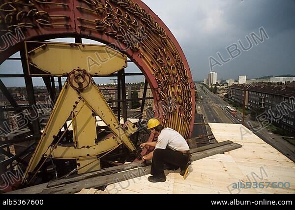 Fall of the Berlin Wall, construction workers removing a GDR symbol in East Berlin, 1990, Berlin, Germany, Europe.