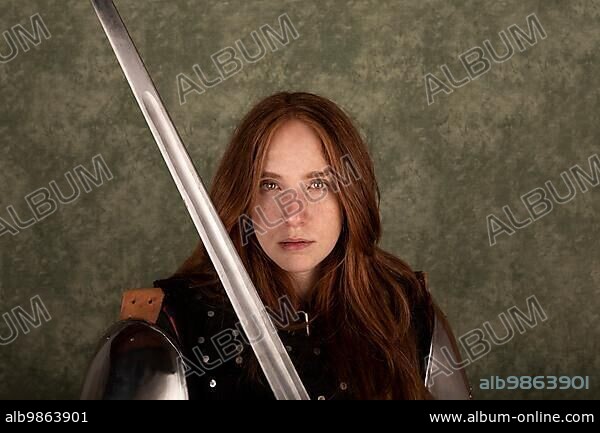 History of the Middle Ages. Portrait of a beautiful medieval female knight in armour on a green background.