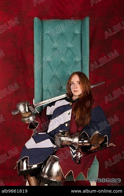 History of the Middle Ages. Portrait of a beautiful medieval knight in armor sitting on a throne on a red background.