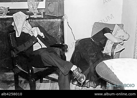 Couples, man and woman sleep exhausted after the party on a chair and armchair, 1920s, Germany, Europe.