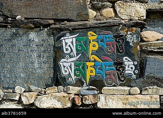 Mani stones with engraved colorful tibetan mantra at a wall, Manang, Manang District, Nepal, Asia.